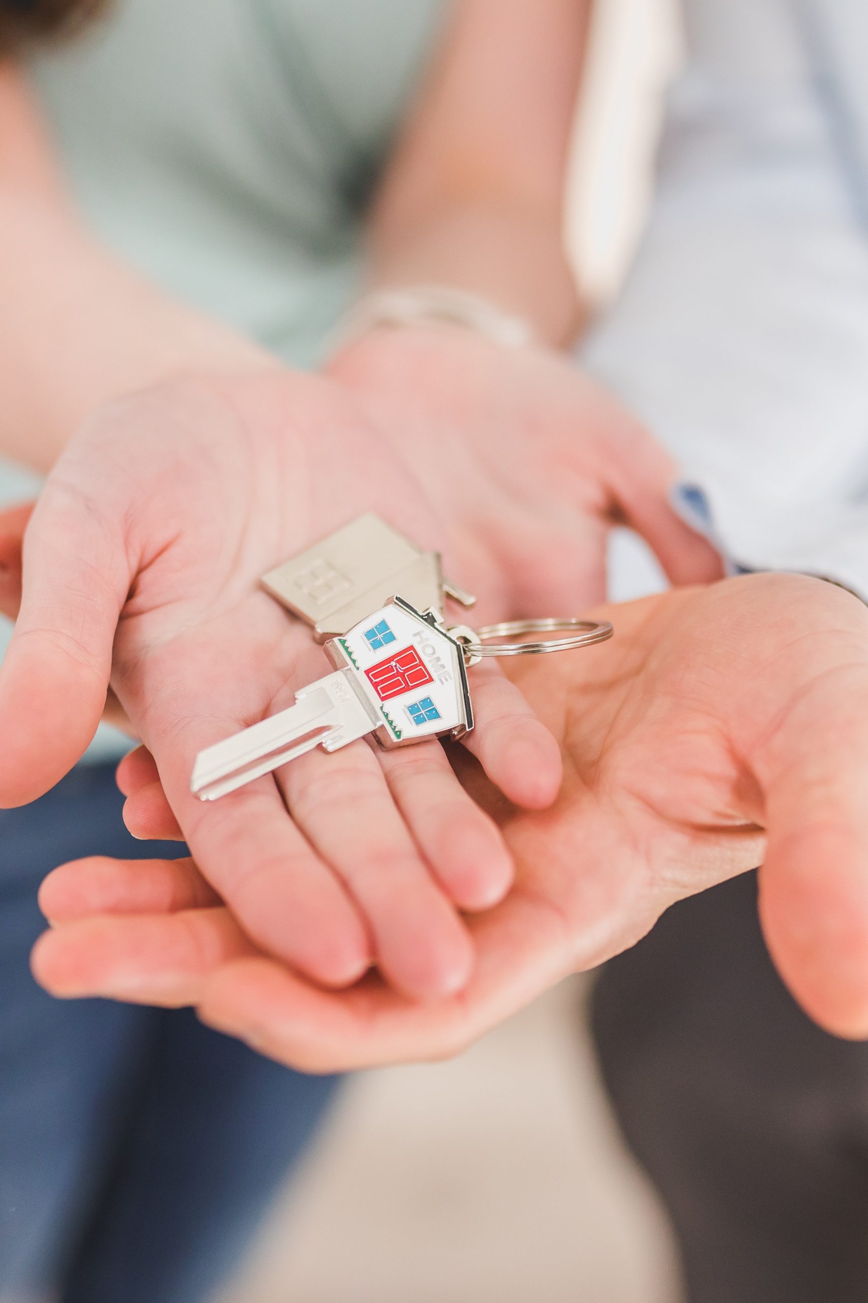 A house key on the palm of two person